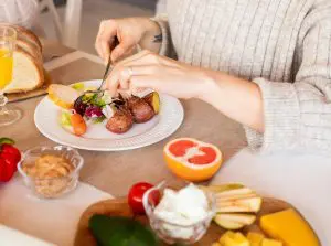 Vrouw aan tafel met eten waar de darmen direct op reageren